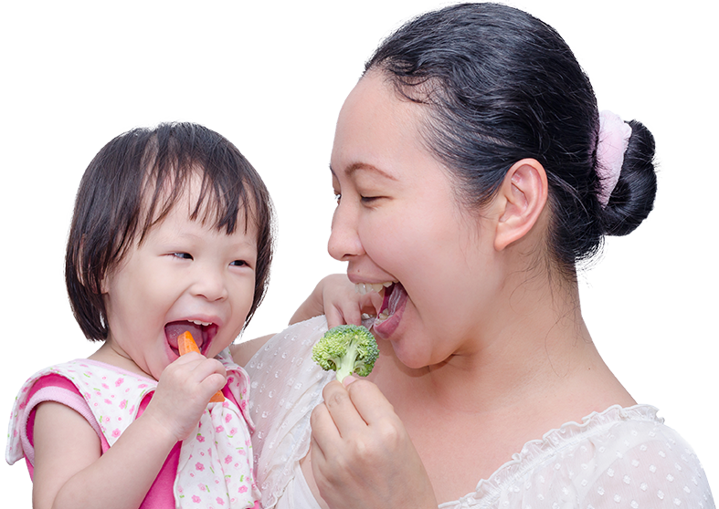 Mẹ và con gái đang ăn rau củ tươi