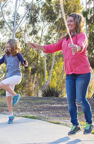 A picture of mom and her daughter jumping rope.