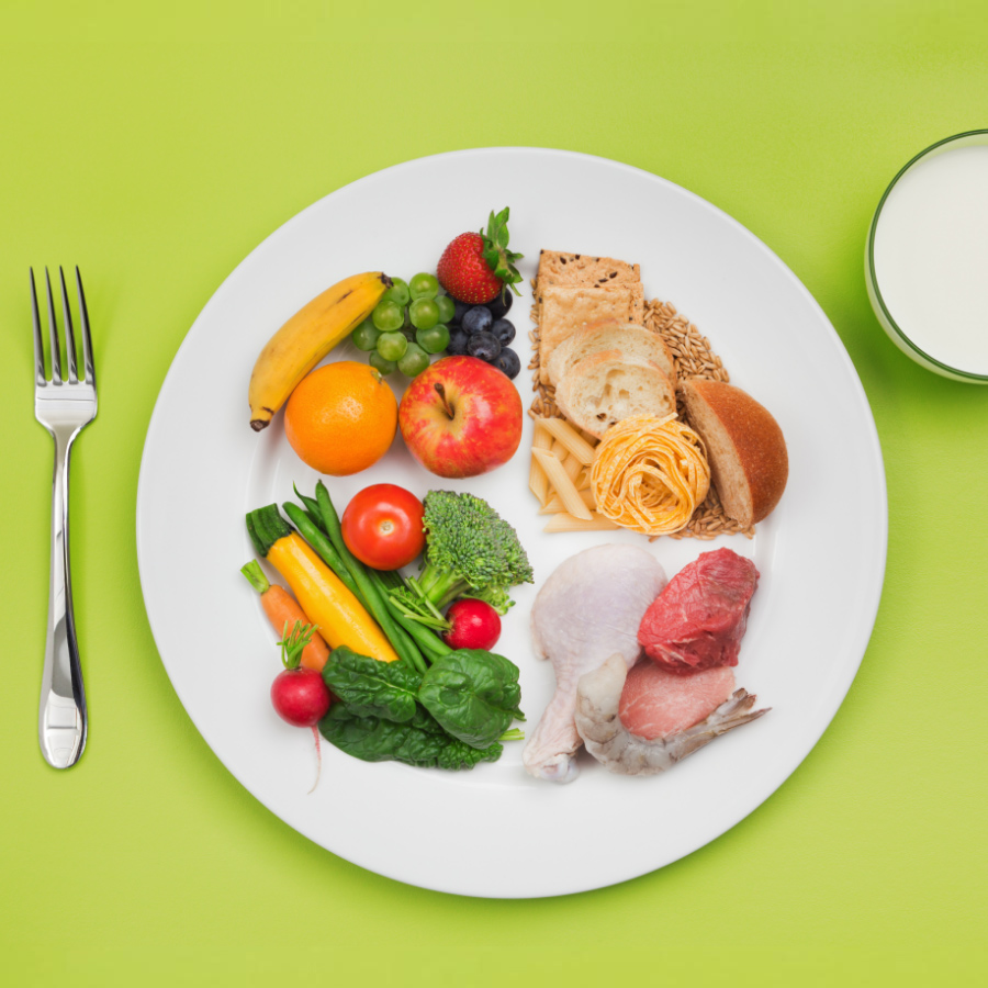 A plate of food with a glass of milk.