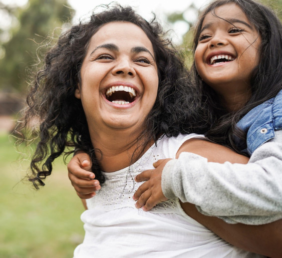 A joyful mother and daughter share a moment of laughter.