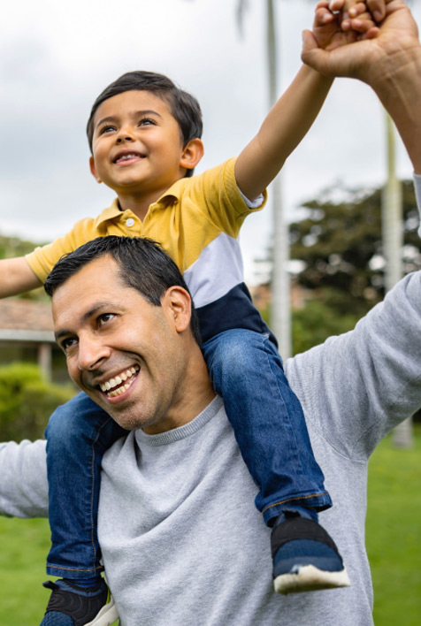 Father and son piggybacking, smiling.