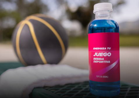 Una botella de bebida deportiva azucarada junto a un balón de baloncesto.