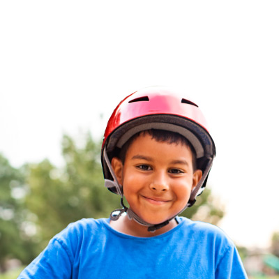 Un niño feliz con casco y una gran sonrisa en su rostro.