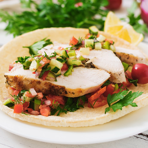 Un plato colorido con comida nutritiva que incluye verduras frescas, proteínas magras y granos integrales.